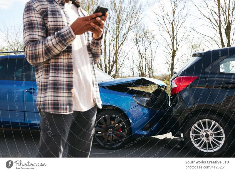 Close Up Of Male Driver Calling Car Insurance Company On Mobile Phone After Road Traffic Accident man driver car accident wreck crash insurance claim calling