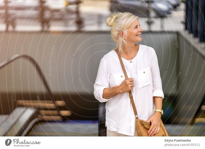 Portrait of senior woman smiling in the city people retired retirement leisure standing confident attractive urban street positive joy enjoyment cheerful happy