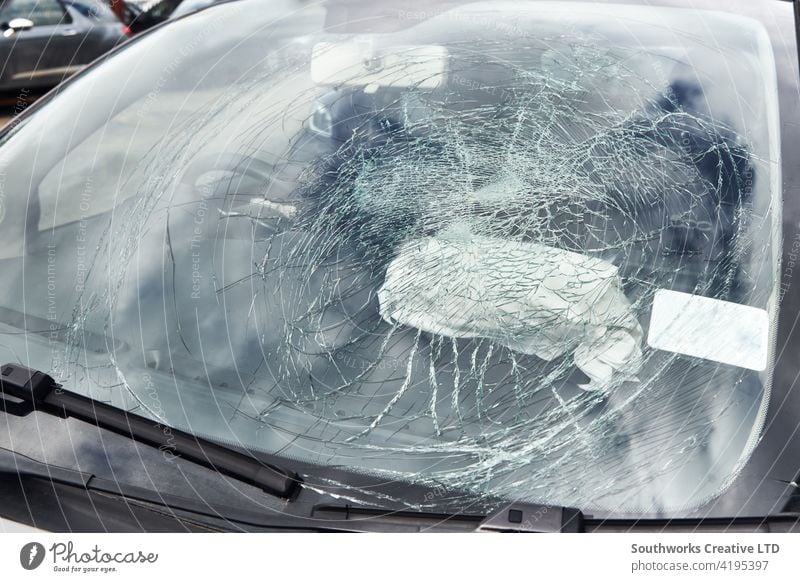 Close up of smashed windshield of vandalized car Car Windscreen Shatter Broken Cracked Glass Parking lot Vandalism Insurance Claim Damage Outdoors Repair