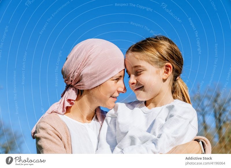 Sick mother with daughter in park woman together cancer love relationship summer happy disease parent smile relax embrace concept pink little girl family child