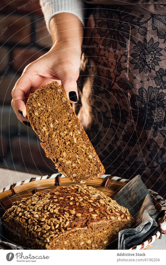 Crop artisan showing cut multigrain bread in bakehouse baker cereal nutrient protein fresh crunchy delicious woman bakery soft yummy table baked tasty sunflower