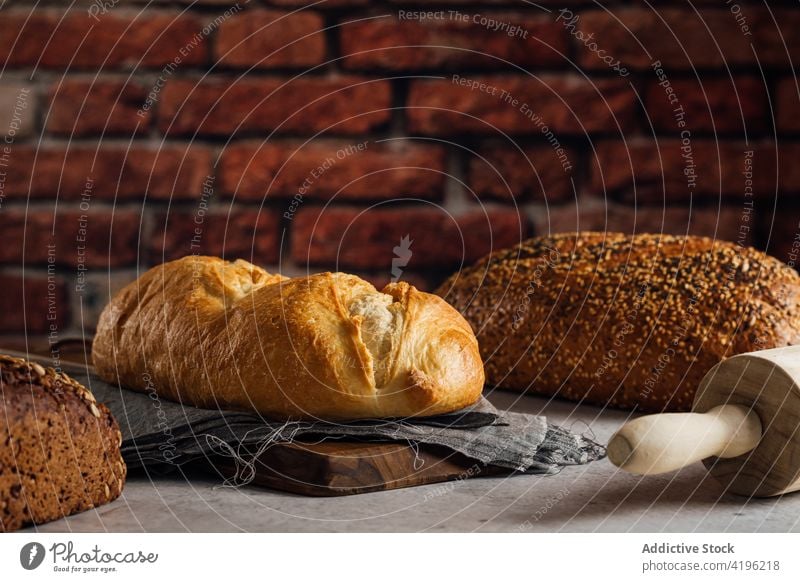 Assorted multigrain loaves of bread in bakery cereal baked nutrient vitamin fresh delicious brick wall loft style rough white rye tasty natural loaf yummy