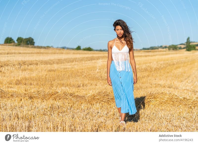 Carefree woman in field in summer dry countryside carefree serene slim grace sunny female harmony peaceful tassel meadow nature idyllic style dried bra skirt