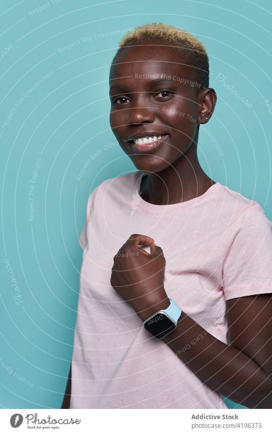 Cheerful black woman with smartwatch in studio smart watch toothy smile model charismatic trendy cheerful show demonstrate style female device african american