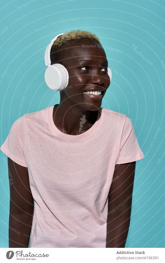 Excited black woman with headphones music african charismatic expressive audio device song gadget female glad american tune short hair listen happy attractive