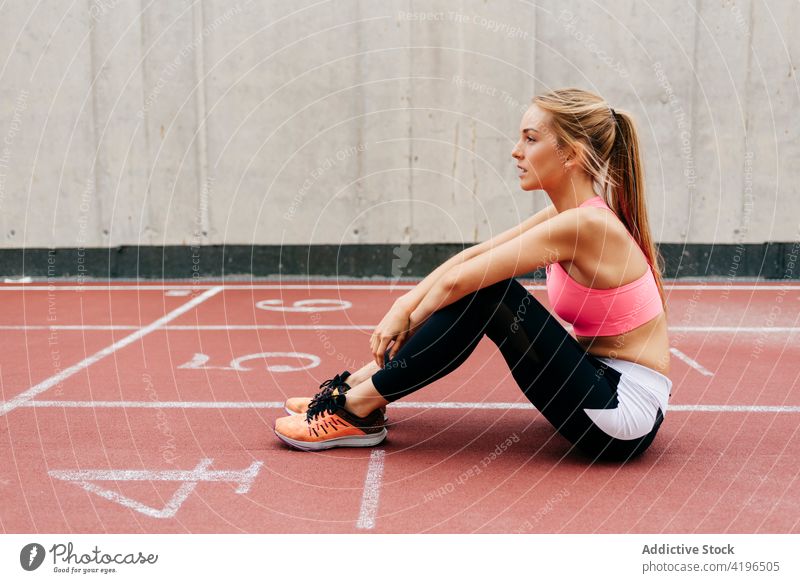 Blonde sportswoman resting on the track blonde city run running exercise lifestyle healthy attractive sportswear preparation athlete female caucasian fit
