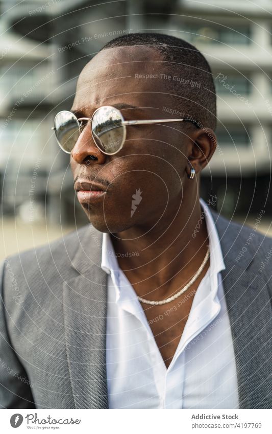 Stylish masculine black businessman in modern sunglasses fashion style individuality macho independent formal cool portrait accessory african american ethnic