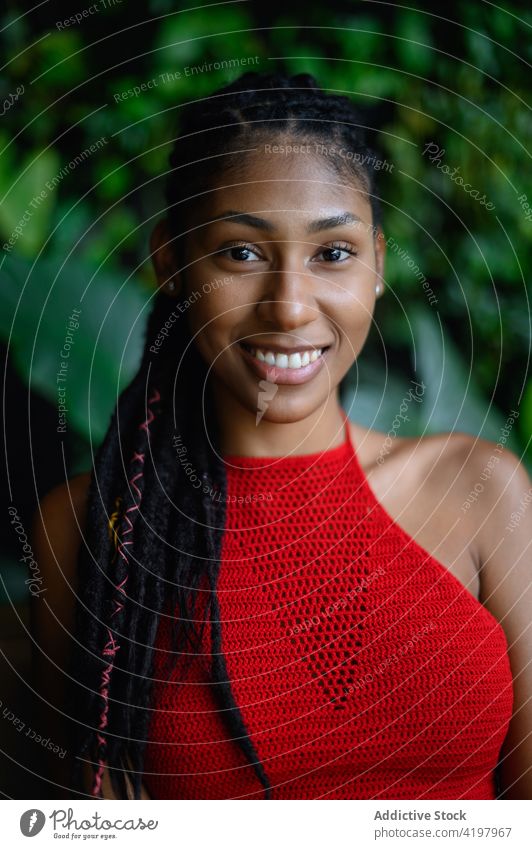 Happy attractive young black woman 20s afro latina happy smile portrait close up dreadlocks rasta posing looking at camera crochet red top stylish Colombia