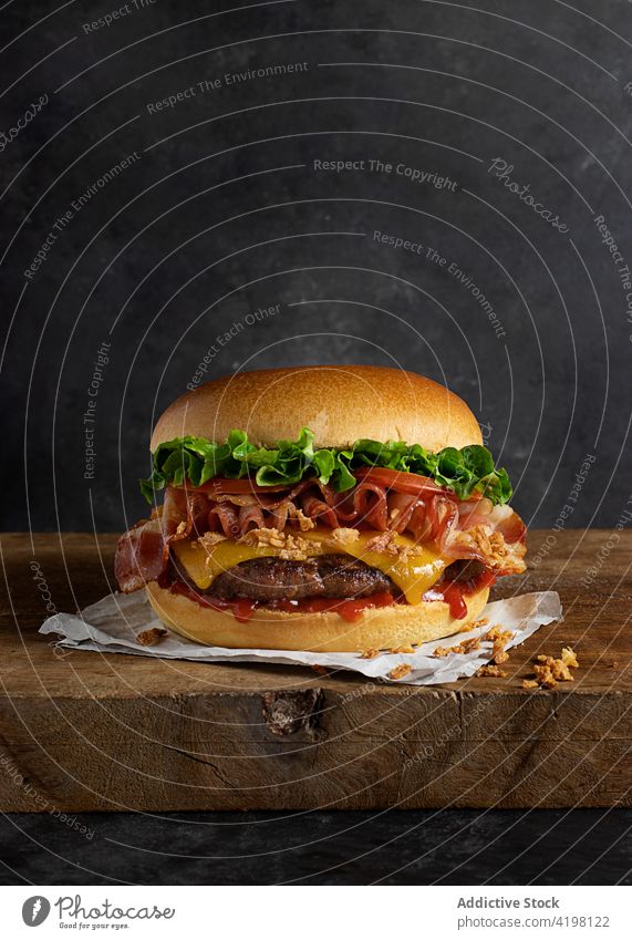 Delicious cheeseburger on wooden table hamburger beef onion sandwich junk ingredient dinner melted one crispy onion lettuce unhealthy cooked takeaway eat
