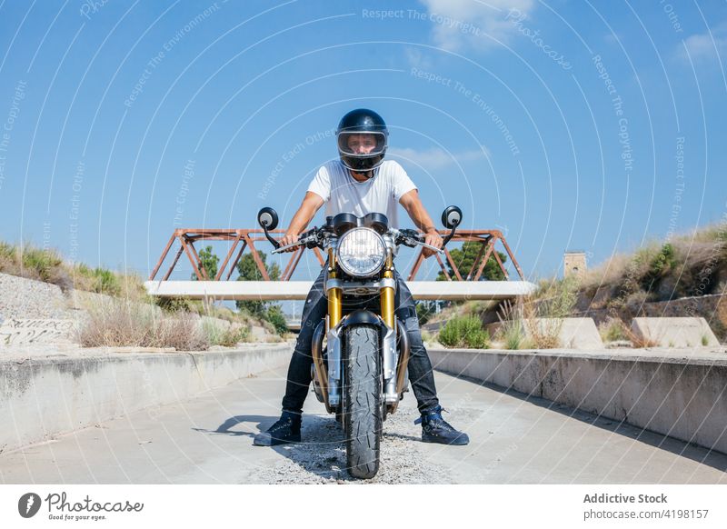 Male motorcyclist on modern bike in suburb biker motorbike man helmet motorcycle protect cool rider confident male style vehicle sit brutal transport handsome