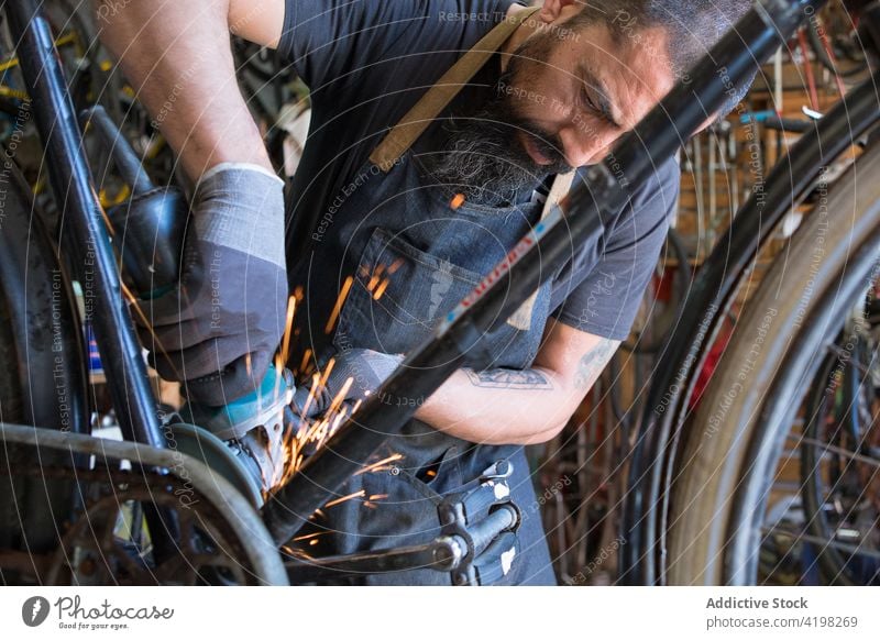 Focused man repairing bicycle in garage vehicle master prepare skill workplace professional male wheel bike rim service tire tool workshop handyman concentrate