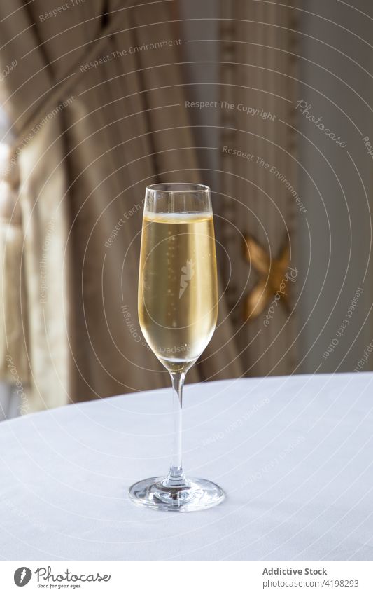 Glass of champagne placed on table in restaurant wine glass alcohol elegant beverage crystal wineglass celebrate serve glassware luxury event daylight simple