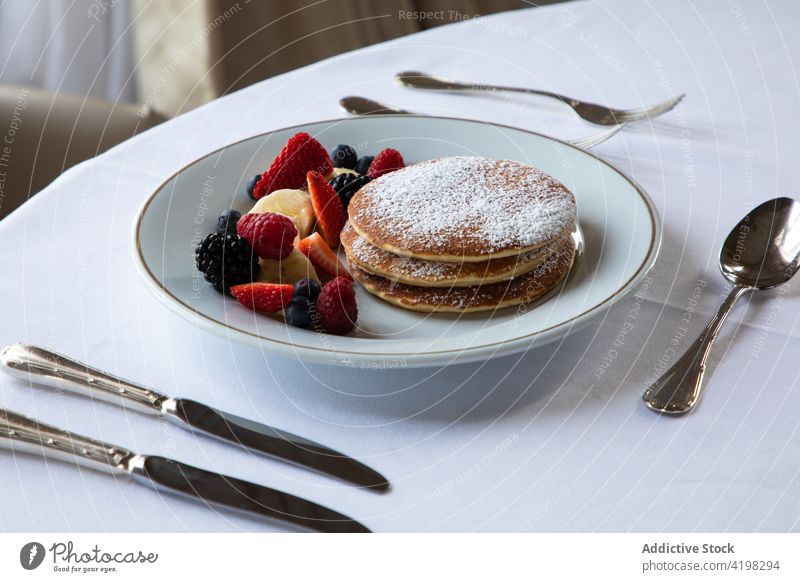 Delicious pancakes with berries served on table in restaurant berry breakfast sugar powder sweet yummy food banana cafe pastry gourmet meal healthy assorted
