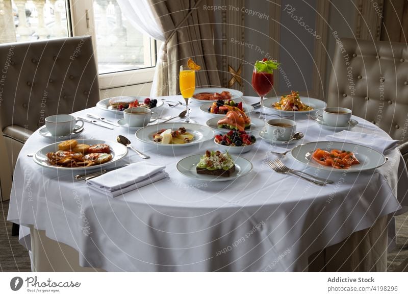 Served table with various dishes and beverages in stylish restaurant table setting juice breakfast food meal delicious elegant coffee fresh colorful hotel