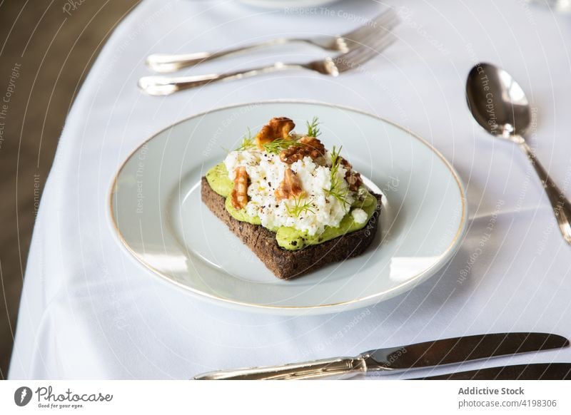 Delicious avocado and ricotta toast served on plate walnut breakfast healthy delicious food meal tasty nutrition morning cafe table dish yummy gourmet portion
