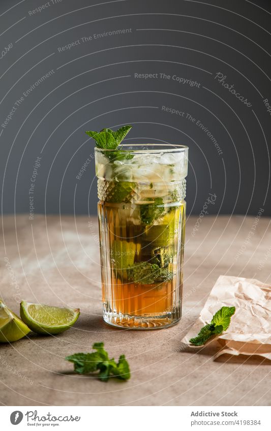 Glass of cold cocktail with lime and mint leaves mojito cut cool refresh rum alcohol ice board tasty citrus drink exotic sour leaf soda lemonade fruit glass