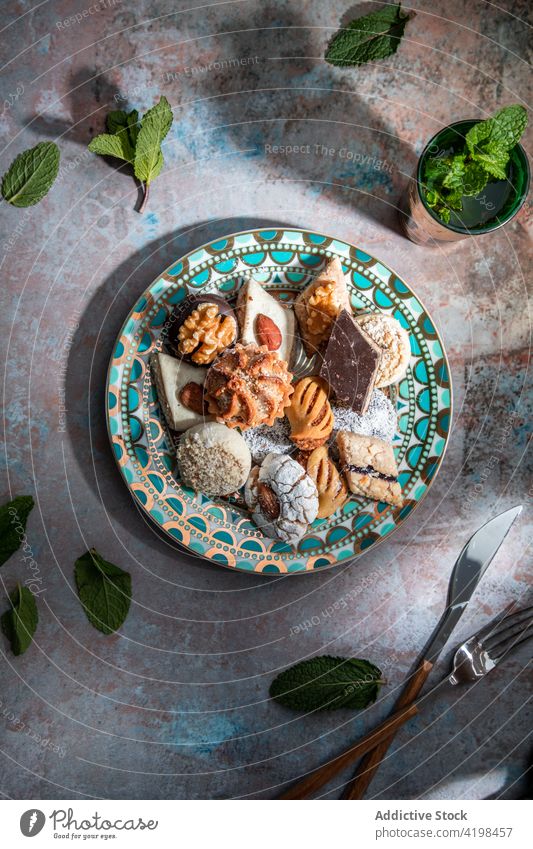 Traditional Middle East sweets with tea in restaurant baklava biscuit baked moroccan peppermint tea knife fork middle east different dessert delicious tasty