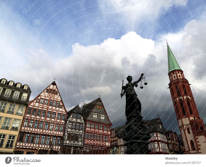The Gerechtigkeitsbrunnen or Justititiabrunnen on the Römerberg with half-timbered houses of the old town and church tower in Frankfurt am Main in Hesse