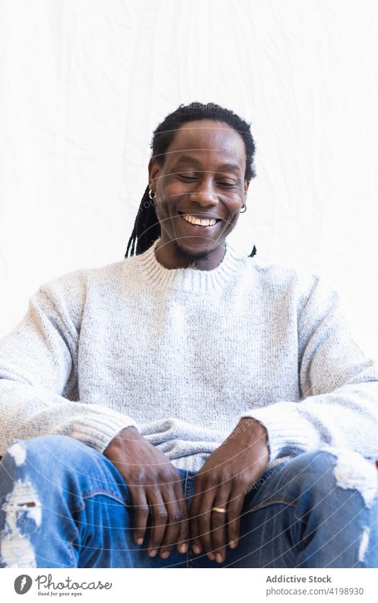 Black man with dreadlocks smiling widely smile positive glad optimist individuality carefree enjoy delight male cloth toothy smile appearance personality fun