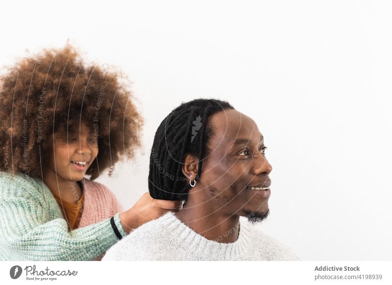 Amazed girl making hairdo on dreadlocks of father daughter amazed shock fun game excited play delight enjoy man dad fatherhood funny wow bright astonish