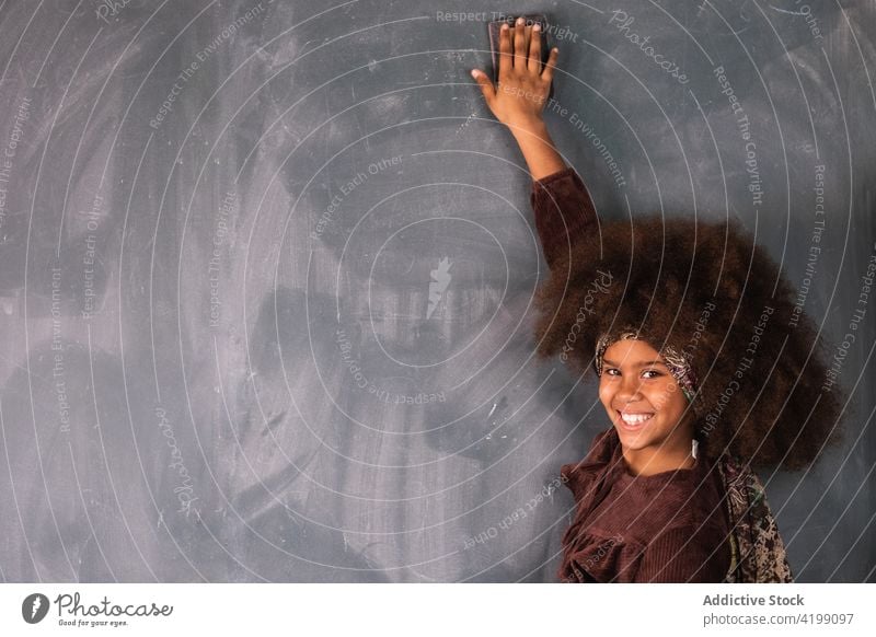 Black girl writing on chalkboard in classroom pupil example solve write lesson blackboard ethnic african american school schoolgirl study clever education