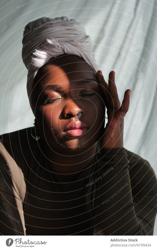 Young black woman with closed eyes touching face eyes closed touch face grace feminine relax tradition style portrait appearance personality calm female young
