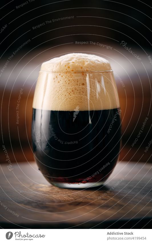 Glass of dark beer on table glass craft porter brew bar drink alcohol foam tasty serve delicious yummy pub froth cold brewery liquid fresh beverage brown booze