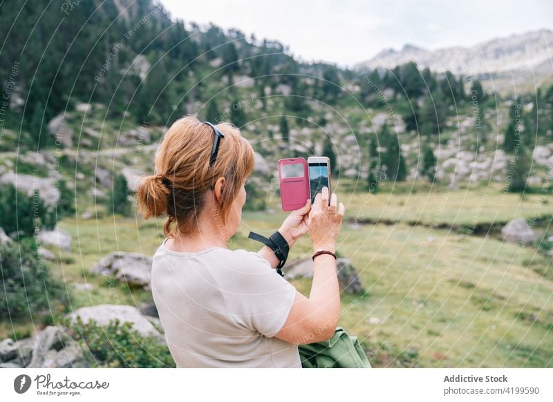 Unrecognizable woman taking photo of scenic mountainous terrain take photo highland smartphone mountaineer travel memory photography amazing verdant ruda valley