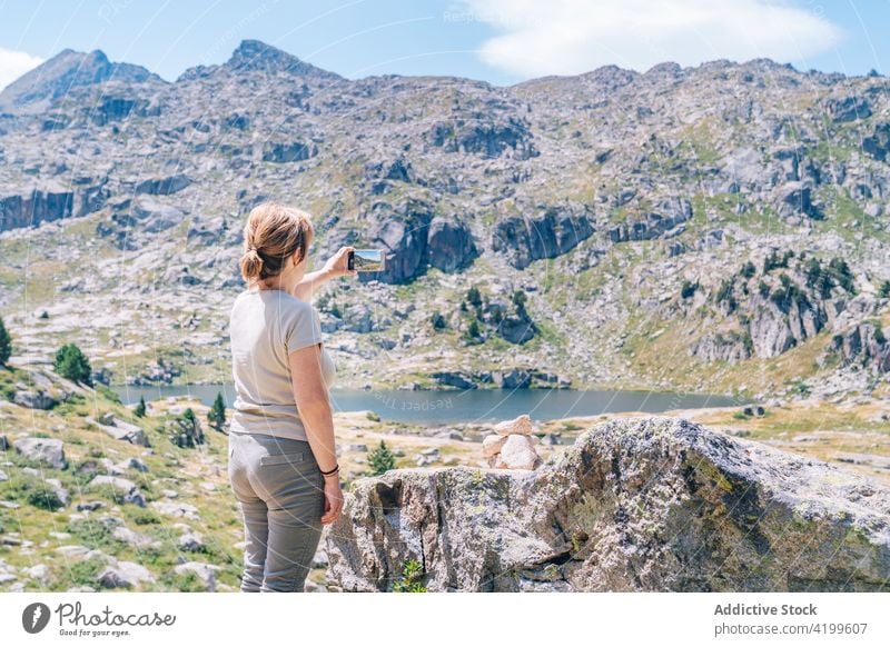Unrecognizable woman taking photo of scenic mountainous terrain take photo highland smartphone mountaineer travel memory photography backpacker ruda valley