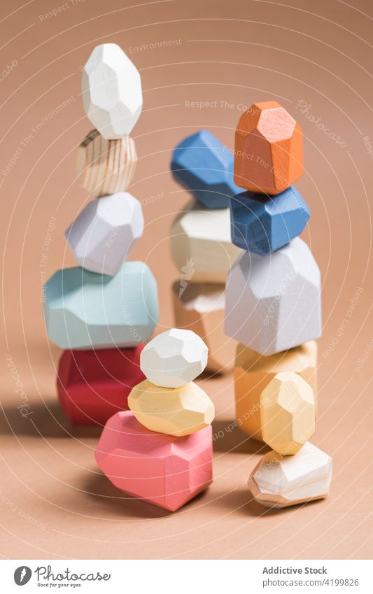 Piles of wooden blocks on beige background pile gem shape geometry balance stack crystal various different size design set heap lumber timber material natural