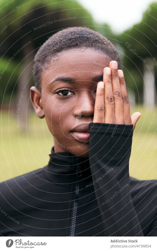 Gentle black woman touching face in city park cover face gentle tender romantic feminine sincere town portrait african american ethnic touch face summer idyllic