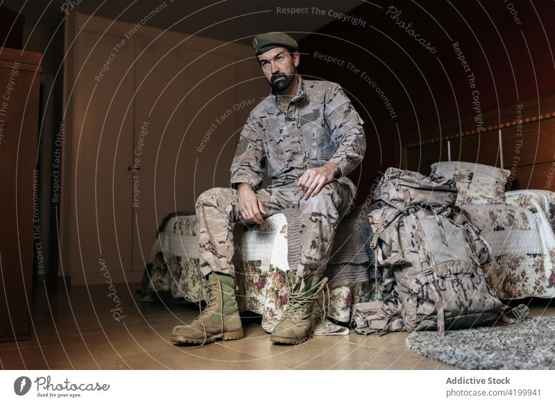 Serious bearded male soldier in camouflage outfit at home man military defend warrior army force serve defense uniform protect fighter brutal ready service