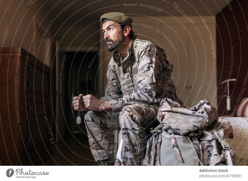 Serious bearded male soldier in camouflage outfit at home man military defend warrior army force serve defense uniform protect fighter brutal ready service