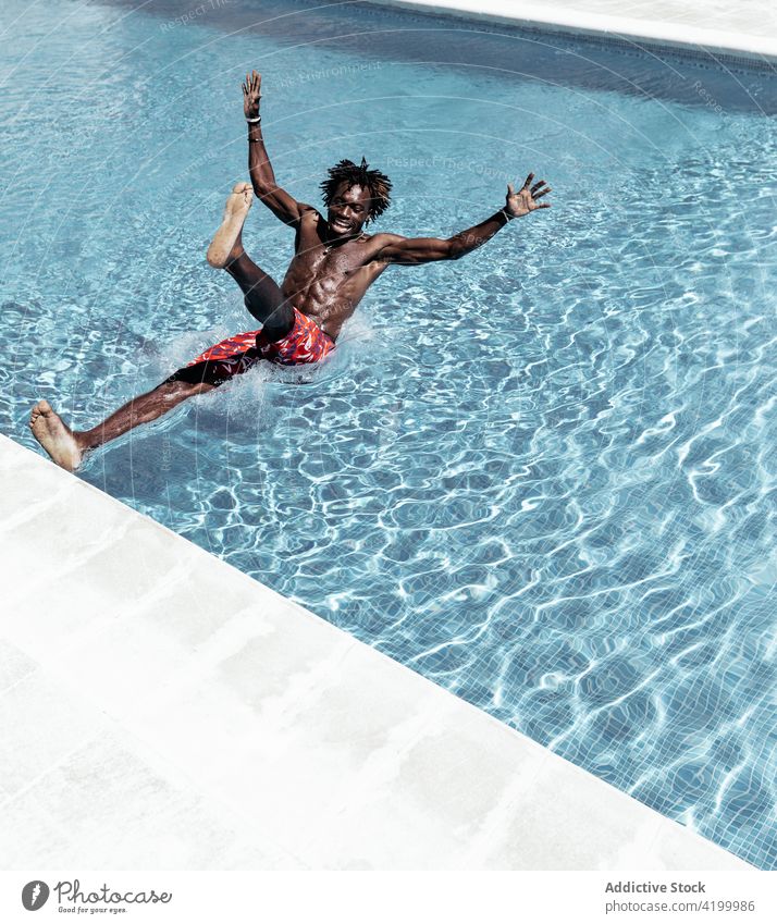 Black man falling into pool astonish slip shock amazed browsing poolside male ethnic black african american mobile phone using online gadget reaction