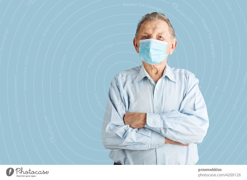 Old aged senior male patient with face mask protection against coronavirus covid-19 person disease health care hygiene copy space man alone clinic covid19