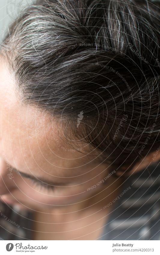 Top of woman's head: gray hair growing in hair care natural grow out dye dye free quarantine silver fresh 40 years old 40 something female wrinkles self care