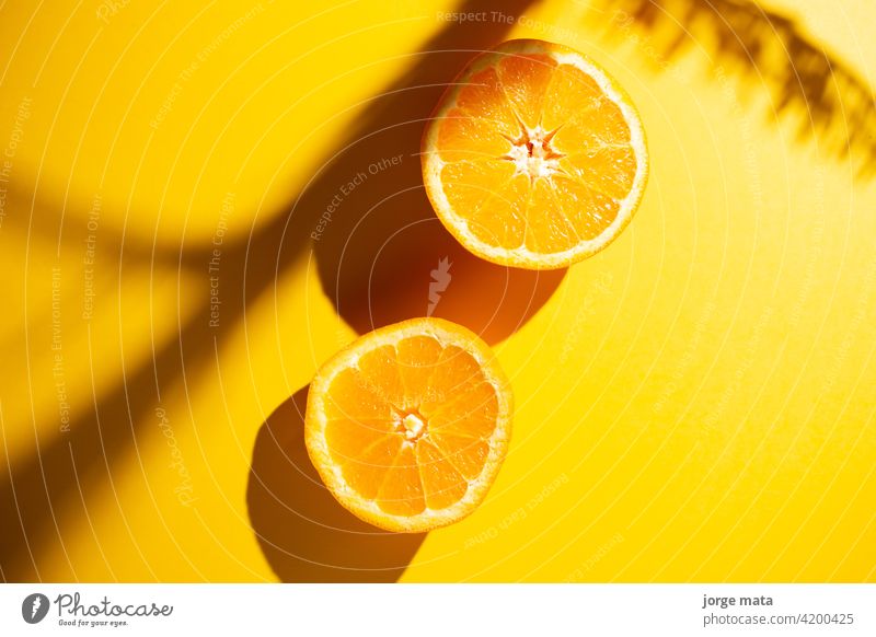2 oranges in spring with yellow background food fruit freshness juicy vitamin pulp colours nourishment citric fruity refreshment tropical organic fruit stand