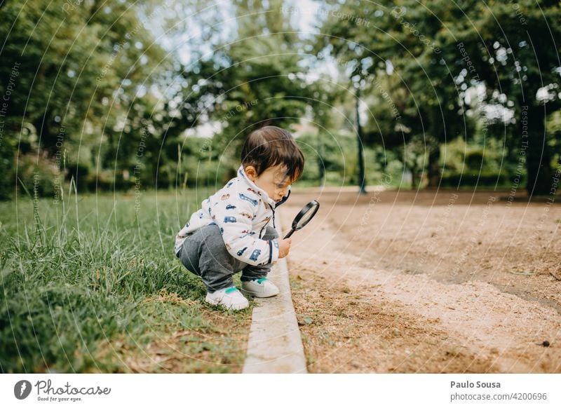 Child playing with magnifying glass 1 - 3 years Caucasian Curiosity Magnifying glass Nature Boy (child) Exterior shot Playing Human being Toddler Joy