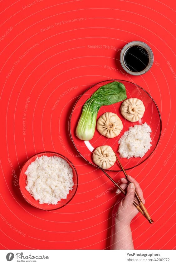 Eating with chopstick chinese steamed food, top view on a red background. above asian bao baozi bok choy bowl bun chopsticks color colorful copy space cuisine