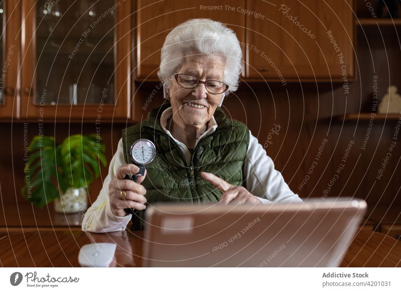 Elderly patient with pressure meter during video chat on tablet video call sphygmomanometer smile show blood woman using gadget device measuring indicate point