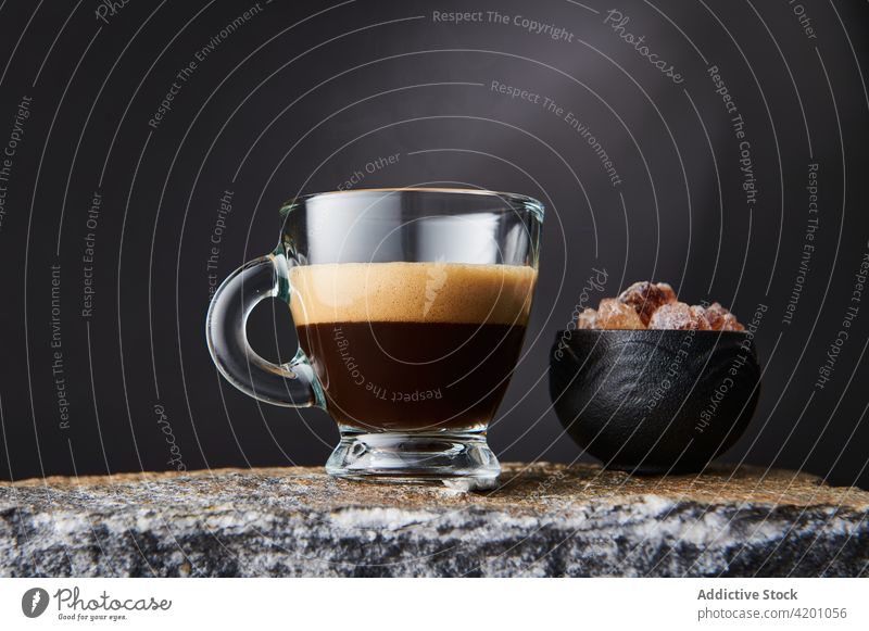 Glass of espresso near cane sugar on stone surface coffee hot drink aroma sweet beverage foam glass creative design delicious cube brown bowl dark strong tasty