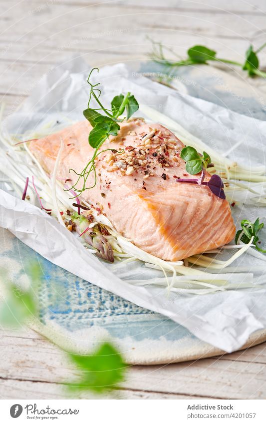 Tasty salmon fillet with fresh green herbs and spices fish lunch seafood menu meal yummy protein nutrient pea sprout dinner delicious tasty baking paper table