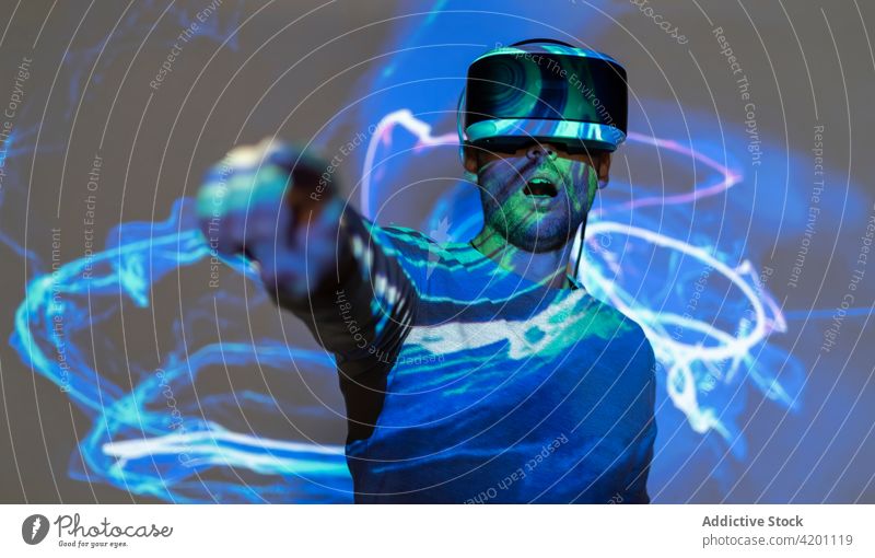 Man in VR goggles exploring virtual reality man vr headset touch experience explore illuminate projector technology innovation gadget entertain digital glasses