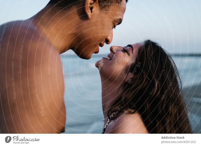 Young black tourist kissing happy beloved against sea boyfriend girlfriend relationship sincere romantic honeymoon travel embrace eyes closed enjoy pleasure hug