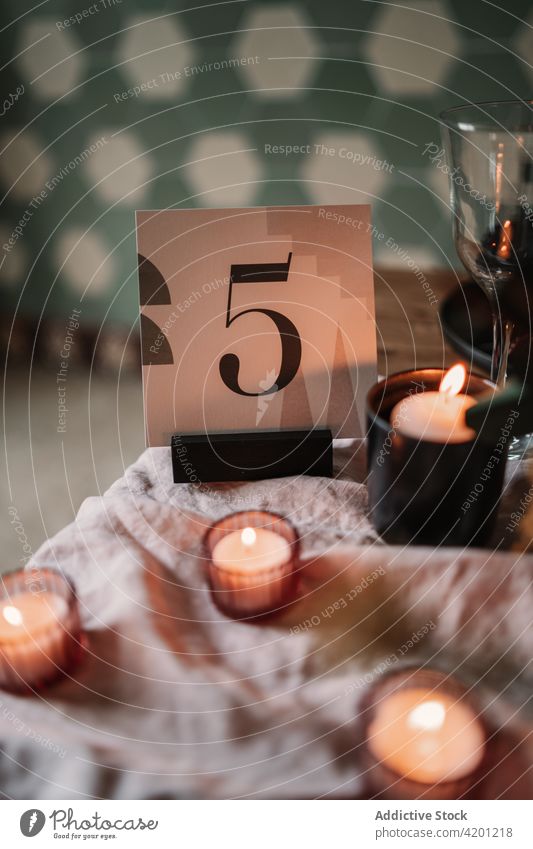 Decor with number and burning candles on table decoration flame creative design festive fabric event occasion hot fire transparent wineglass material cardboard