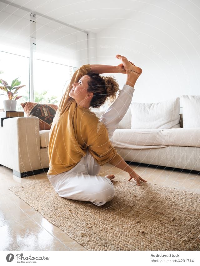 Female doing Compass pose while practicing yoga at home woman calm surya yantrasana stretch compass pose wellness activity female wellbeing zen concentrate sit
