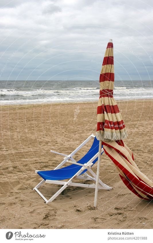 deckchair and sunshade on the beach of trouville Sunshade Deckchair Umbrellas & Shades Striped Closed Beach Sandy beach Empty Lonely forsake sb./sth. Ocean