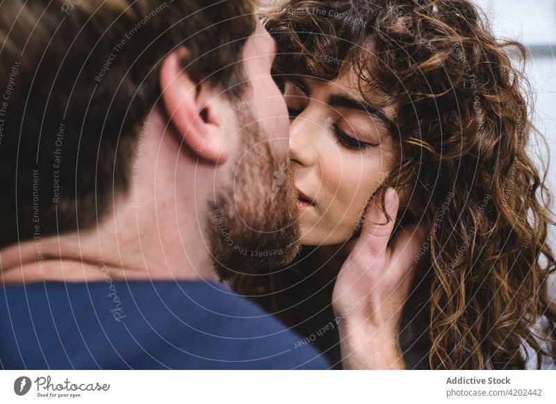 Happy young couple kissing each other hug embrace together happy fondness romantic tender love relationship boyfriend girlfriend date bonding close amorous joy