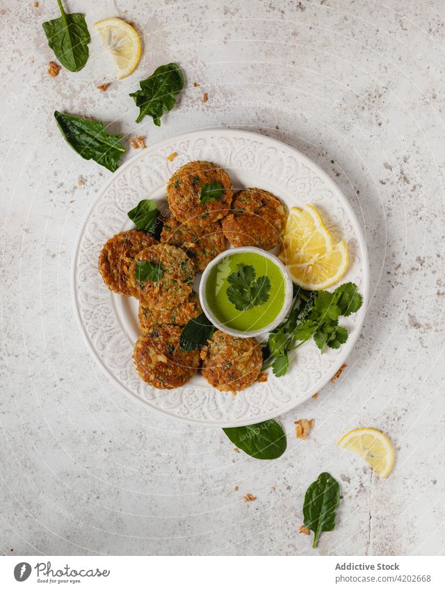 Delicious vegetable fritters served with green sauce and lemon herbal healthy appetizing composition vegetarian food cuisine culinary yummy delicious meal fresh