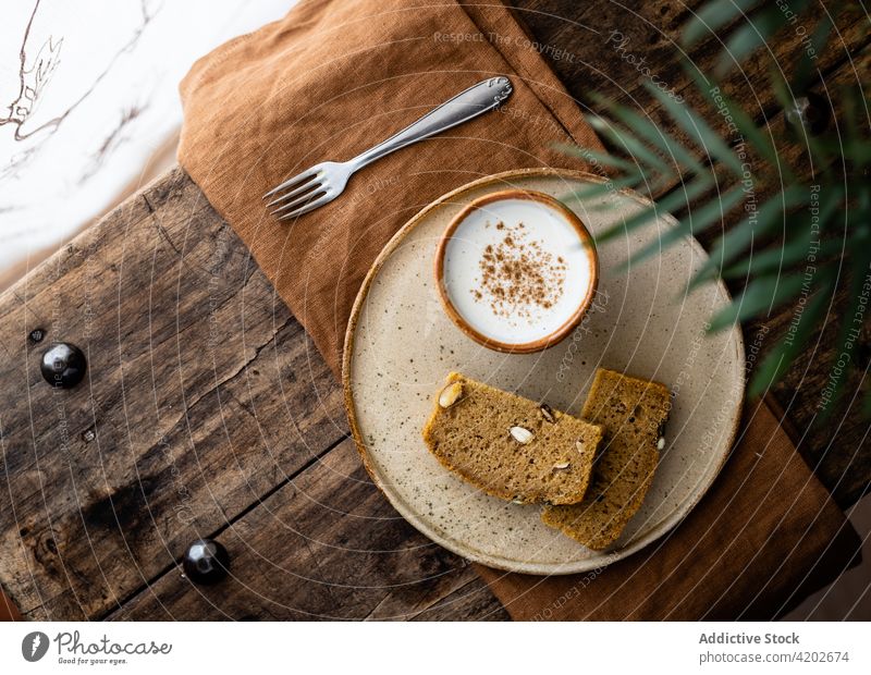 Slices of wholegrain loaf served on plate with milk cup bread wholesome snack baked slice tasty fresh pumpkin appetizing seed pastry nutrition delicious